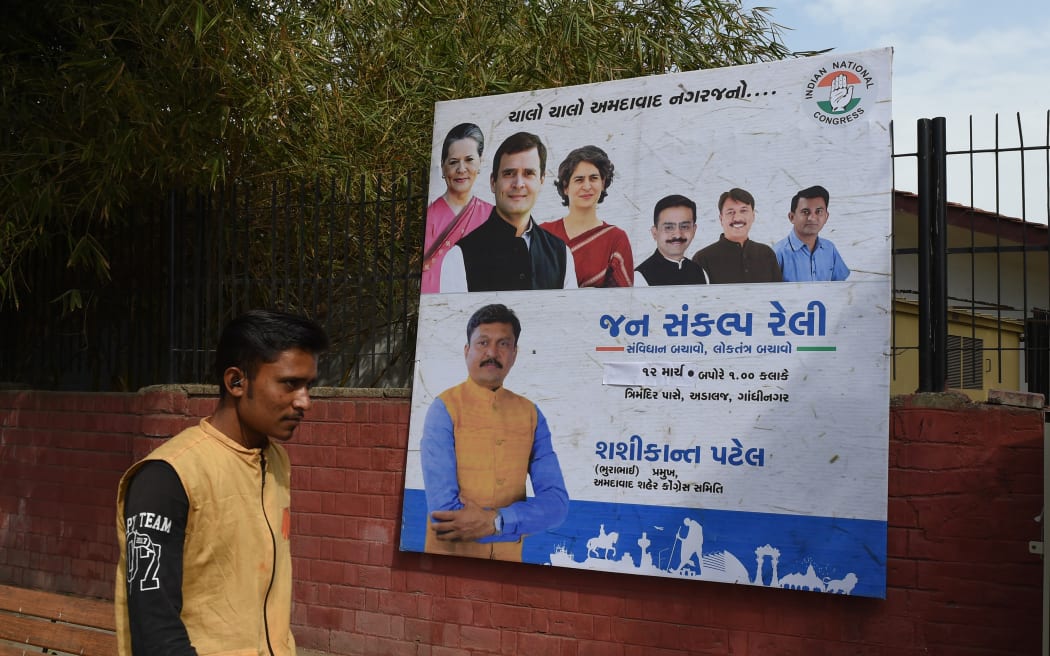 An Indian man walks in front of a billboard depicting India's Congress Party president Rahul Gandhi