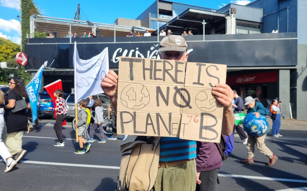 2023 年 5 月 26 日在奥克兰气候抗议活动中举着“没有行星 b”标语牌的抗议者