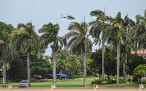 A helicopter flies near the residence of former US President Donald Trump at Mar-A-Lago in Palm Beach, Florida, on August 9, 2022. - Former US President Donald Trump said on August 8, 2022, that his Mar-A-Lago residence in Florida was being "raided" by FBI agents in what he called an act of "prosecutorial misconduct." (Photo by Giorgio VIERA / AFP)