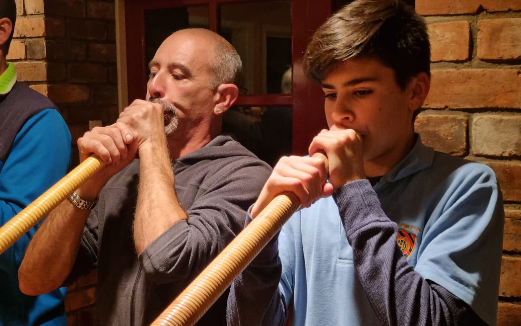 Aaron Boesch (left) plays the alphorn his father brought to New Zealand from Switzerland.  Ryan Bühler (right), 15, is the youngest of the alpine horn players of the Taranaki Swiss Club.