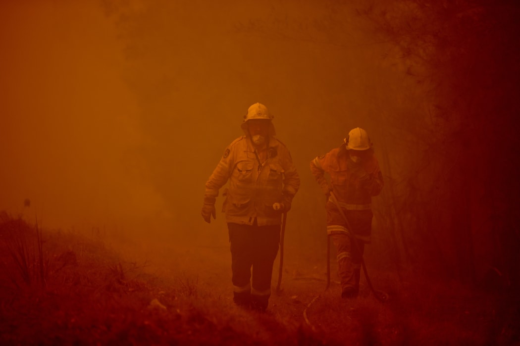 Firefighters tackle a bushfire in the town of Moruya, south of Batemans Bay, in New South Wales.