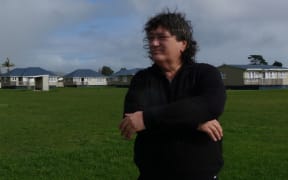 Ricky Houghton in front of the affordable housing project, Whare Ora.