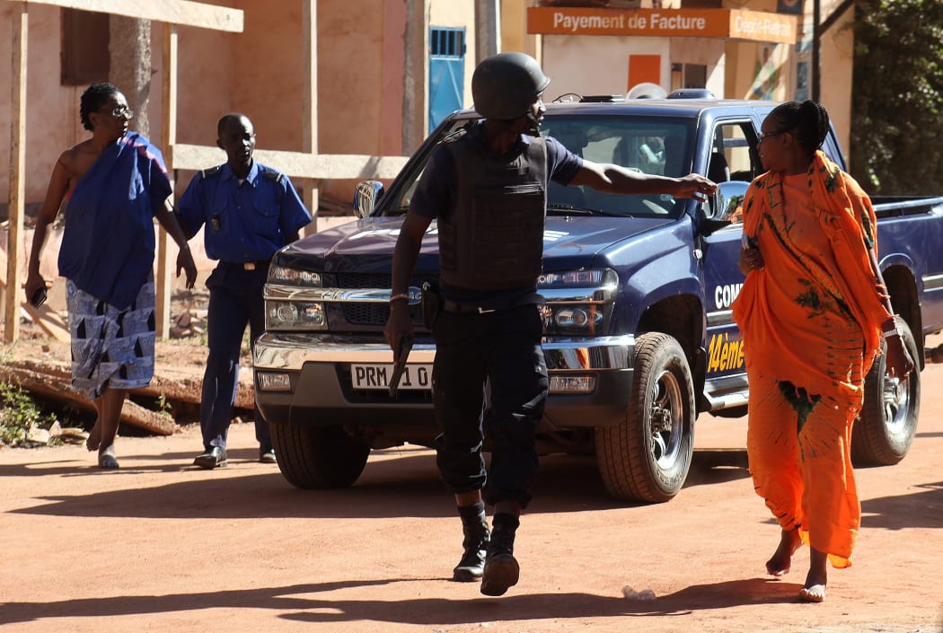 Malian security forces evacuate two women from an area surrounding the Radisson Blu hotel in Bamako