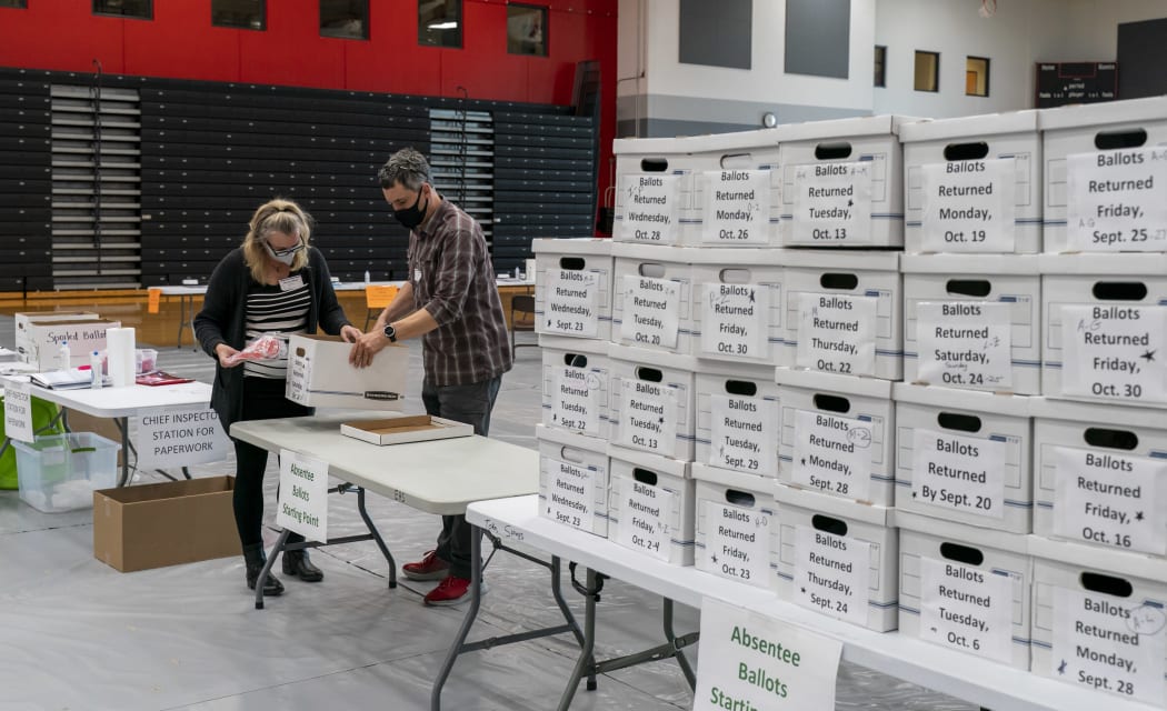 Poll workers check in a box of absentee ballots in Sun Prairie, Wisconsin, on 3 November 2020.