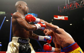 Floyd Mayweather exchanges punches with Manny Pacquiao.