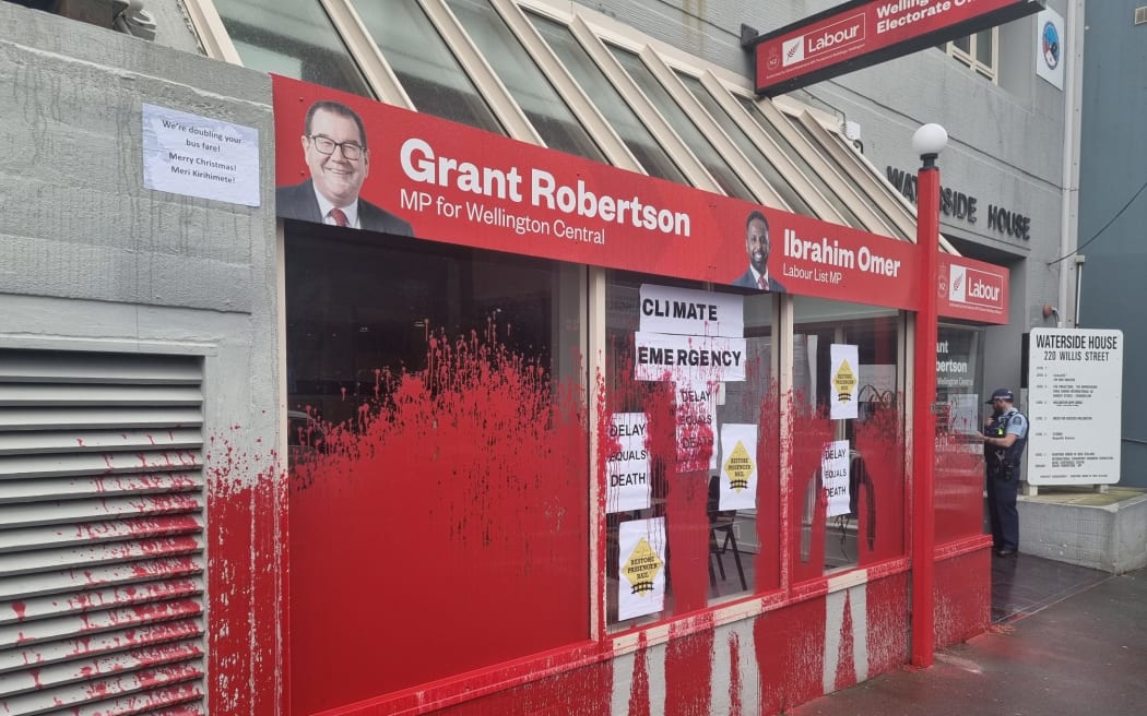 The electorate office of Deputy Prime Minister Grant Robertson is covered in red paint, and a sign reading 'climate emergency' is on the window,