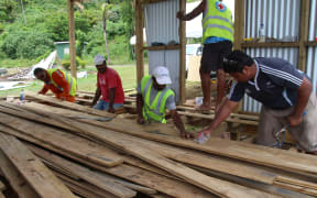 Workers lay the floor for a new disaster shelter on Koro island