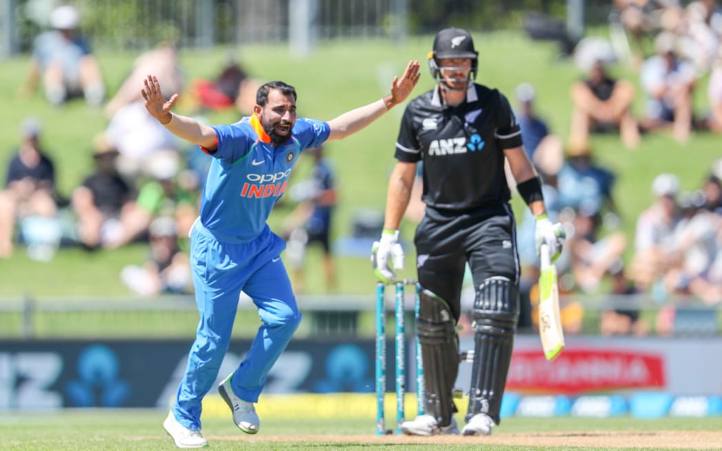 Indian bowler Mohammed Shami with Martin Guptill in the background.