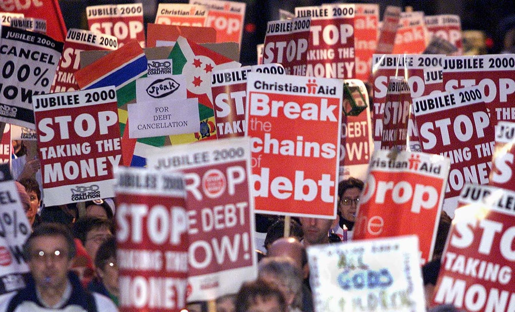 Banners are carried through the streets of London for the Jubilee 2000 March in aid of Western countries cancelling third world debt (London 2 December, 2000)