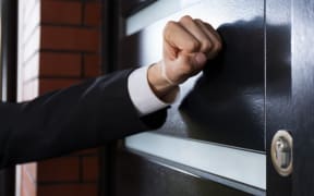 Close-up of hand knocking on the door