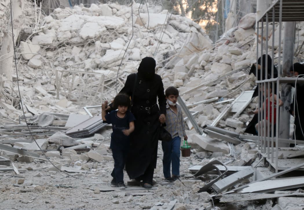 A Syrian family following a reported airstrike on the  al-Muasalat area in the northern Syrian city of Aleppo.