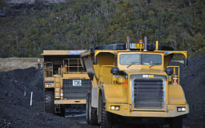 Huge trucks move high-grade coal from a stockpile at the Stockton Mine near Westport.