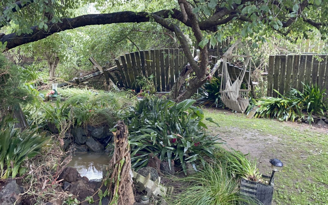 The fences in the garden of Annette Kennedy's West Auckland home buckled as the raging waters flowed through her property on 27 January, 2023.