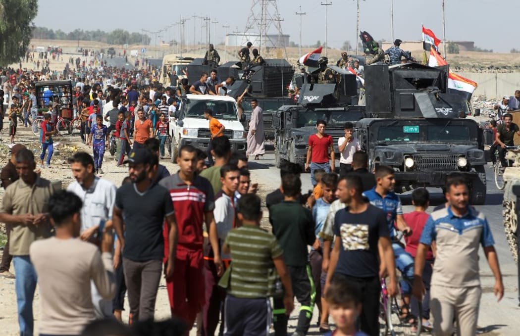 Civilians gather as Iraqi forces arrive in the southern outskirts of Kirkuk.