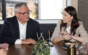 New Zealand Prime Minister Jacinda Ardern (R) speaks with MP Kelvin Davis and other senior members of parliament a day after her landslide election win, in Auckland on October 18, 2020.