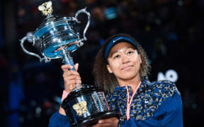 Japan's Naomi Osaka poses with the Daphne Akhurst Memorial Cup trophy after defeating Jennifer Brady of the US in their women's singles final match on day thirteen of the Australian Open tennis tournament in Melbourne on February 20, 2021.
