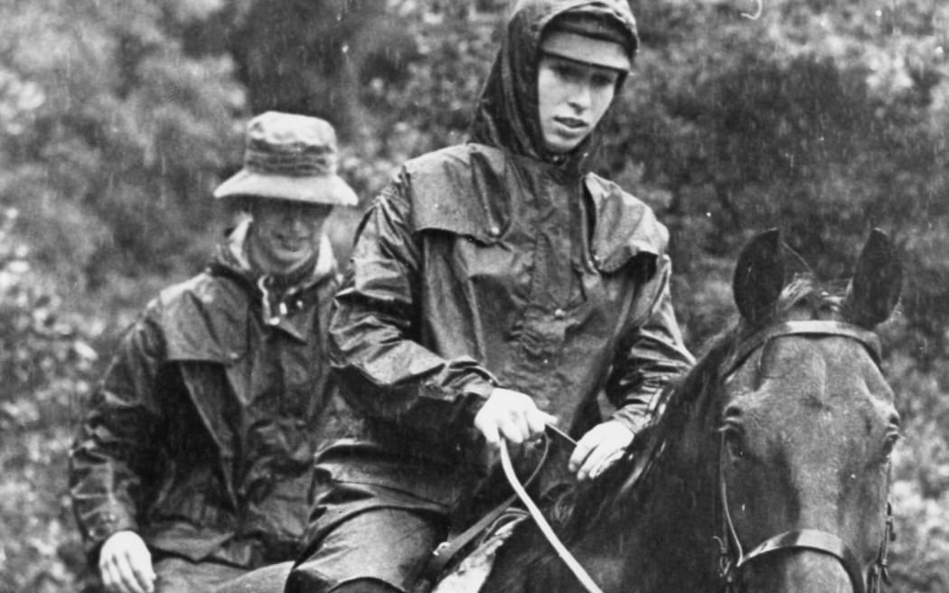 Princess Anne and the future King Charles riding in pouring rain at Mt Peel Station, NZ.