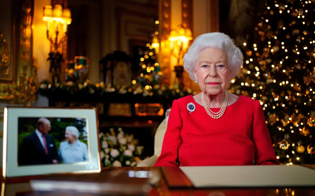 La reine Elizabeth II pose pour une photo alors qu'elle enregistre son dernier message le jour de Noël, avec une photo d'elle-même et de son défunt mari, le prince Philip, duc d'Édimbourg, au château de Windsor, à l'ouest de Londres.