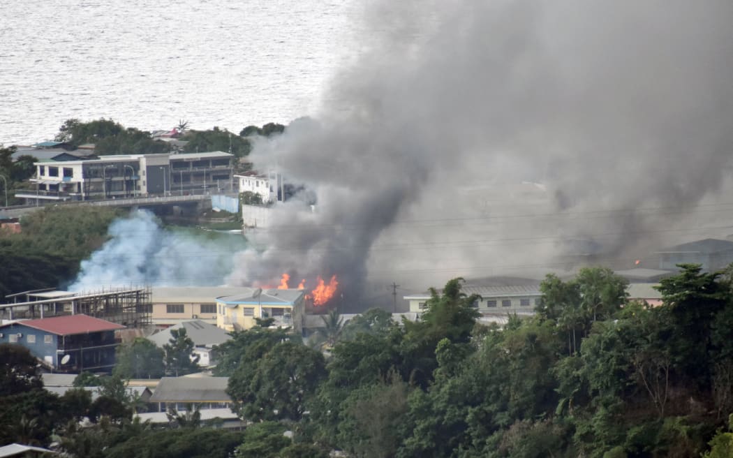 Smoke from fires rise from buildings in Honiara on the Solomon Islands on November 25, 2021, on the second day of rioting that left the capital ablaze and threatened to topple the Pacific nation's government.