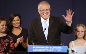 Australian Prime Minister Scott Morrison, second right, speaks to party supporters flanked by his wife, Jenny, second left, and daughters Lily, right, and Abbey, after his opponent concedes in the federal election in Sydney, Australia, Sunday, May 19, 2019.
