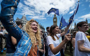 Marchers wave EU flags in London's Parliament Square as thousands protest against Britain's vote to leave the union.