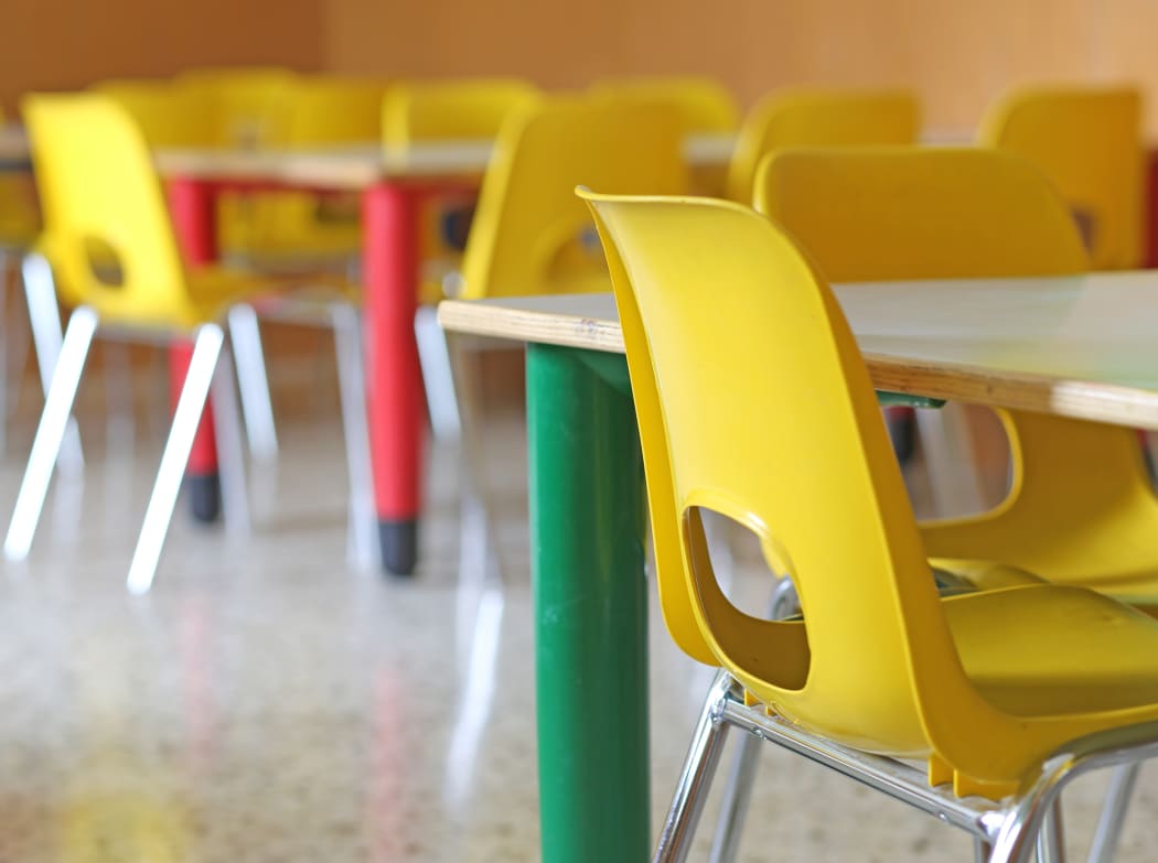 A file photo shows bright yellow chairs in a kindergarten or pre-school.