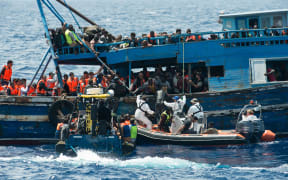 Migrants on a wooden boat during a rescue operation in the Mediterranean sea on August 26, 2015. At least 55 dead bodies were found. Almost all of the victims were found in the hold of a wooden boat found drifting precariously off the Libyan coast. They had choked to death on gas fumes.