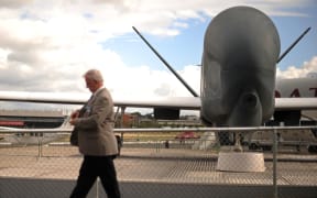 A visitor walks past a Northrop Grumman RQ-4 Global Hawk unmanned aircraft at the Farnborough International Airshow in Hampshire, southern England, on July 22, 2010.