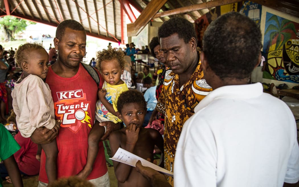Families shelter at a Honiara evacuation centre.