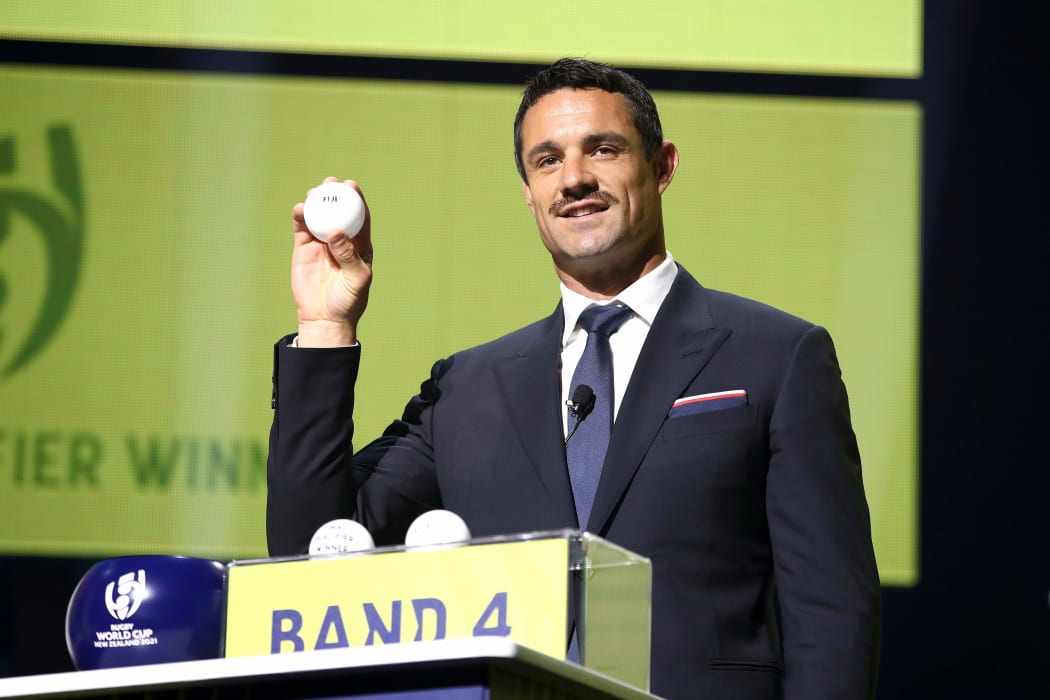 Former All Black Dan Carter displays Fiji's ball during the 2021 Rugby World Cup draw.