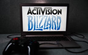 Activision Blizzard logo displayed on a laptop screen and a gamepad are seen in this illustration photo.