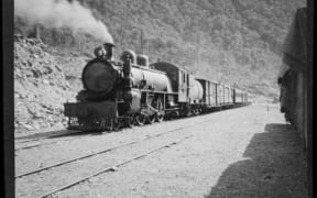 Goods and passenger steam train at unidentified railway station on the West Coast, circa 1910s-1930s