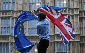 File photo taken on June 28, 2016. A  man waves both a Union flag and a European Union (EU) flag outside The Houses of Parliament at an anti-Brexit protest in central London.