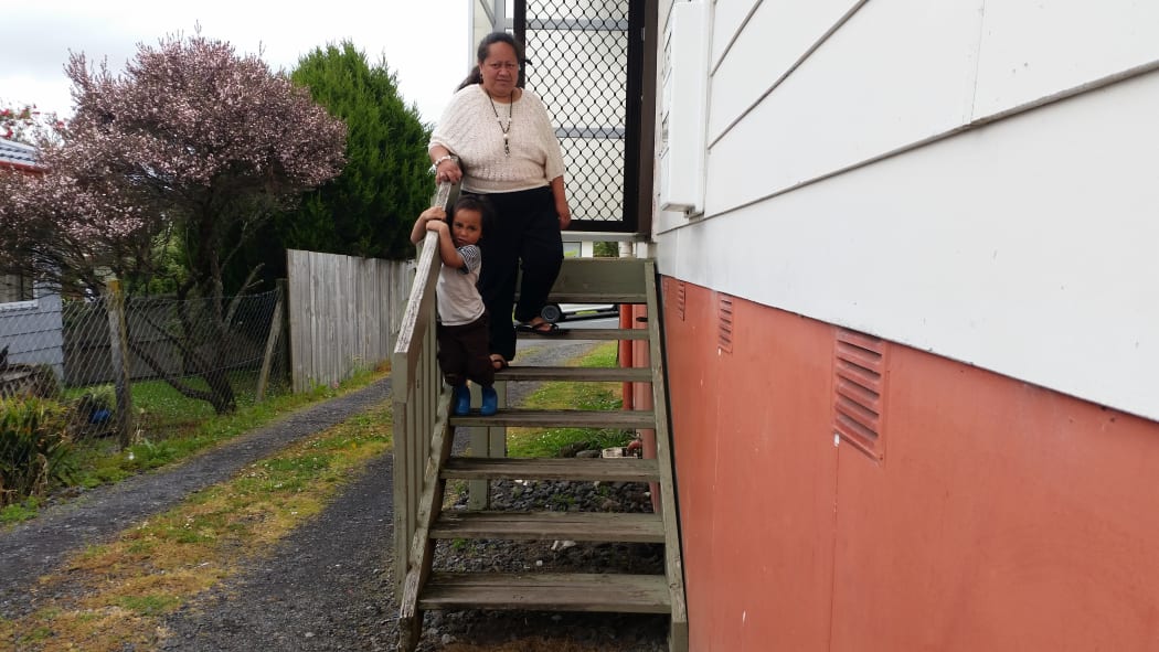 Gia Seuseu and her youngest son on the steps of her Glen Eden home.