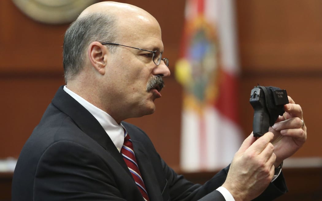 Assistant state attorney Bernie de la Rionda as he shows George Zimmerman's gun to the jury while presenting the state's closing arguments against Zimmerman during his trial in Seminole circuit court in Sanford, Florida.