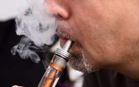 A man smokes using an e-cigarette, known as vaping (file photo)