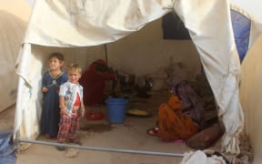 Displaced Iraqis from the embattled city of Fallujah cook at a camp where they are taking shelter some 18 kilometres from Ramadi on June 18, 2016.