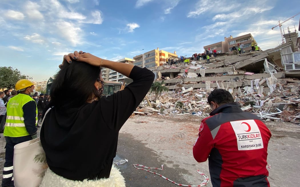 IZMIR, TURKEY - OCTOBER 30: A woman reacts as search and rescue works continue at debris of a building after a magnitude 6.6 quake shook Turkey's Aegean Sea coast, in Izmir, Turkey on October 30, 2020.