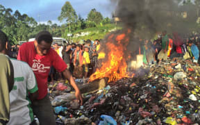 A photo taken on February 6, 2013 shows a young mother accused of sorcery who was stripped naked, reportedly tortured with a branding iron, tied up, splashed with fuel and set alight on a pile of rubbish topped with car tyres, in Mount Hagen city in the Western Highlands of Papua New Guinea.