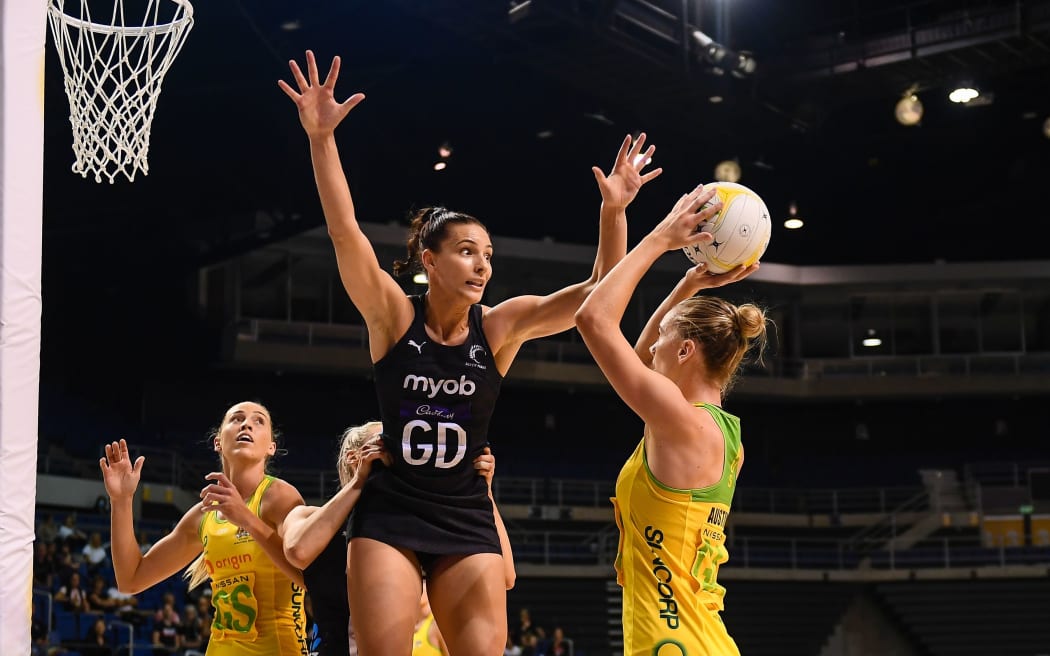Kiera Austin of the Diamonds shoots under pressure from Karin Burger of the Silver Ferns.