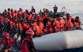 This handout picture obtained on June 22, 2018 from the German NGO 'Mission Lifeline' shows migrants on an inflatable boat beeing rescued before boarding the 'Lifeline' sea rescue boat at sea on June 21, 2018.