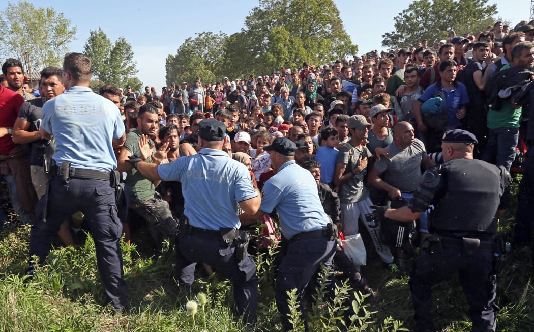 Migrants break a police cordon as they rush to waiting buses in Tovarnik, close to the Croatian-Serbian border on 17 September.