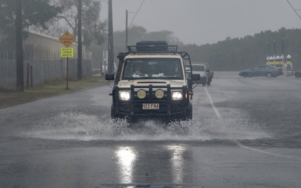 Kierowca przejeżdża przez wody powodziowe, gdy cyklon Jasper zbliża się do miejsca wyjścia na ląd w Cairns na dalekiej północy stanu Queensland 13 grudnia 2023 r. Cyklon tropikalny przybierał na sile, gdy 13 grudnia przemieszczał się w kierunku północno-wschodniej Australii – zgodnie z ostrzeżeniem władz 