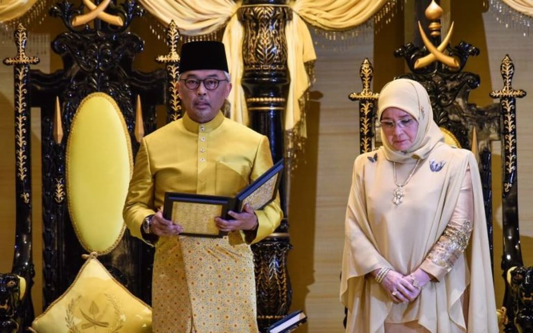 The sixth Sultan of Pahang, Sultan Abdullah ibni Sultan Ahmad Shah (L) taking the oath beside his consort Tunku Azizah Aminah Maimunah Iskandariah, (R) during their coronation at Istana Abu Bakar Palace in Pekan, Pahang.