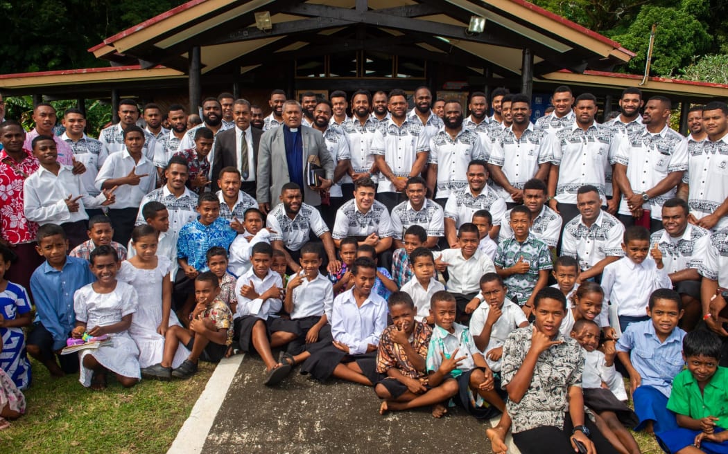 Fiyianos voladores con aldeanos de la aldea de Somosomo en Taveuni después de su servicio dominical el 2 de julio de 2023.