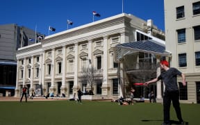 Wellingtonian's embracing a hot lunch break as the 5 flags up for debate fly high on top of Wellington's Town Hall.