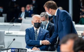 U.S President Joe Biden shakes hand with French President Emmanuel Macron at the United Nations Climate Change Conference COP26 in Glasgow, Scotland, on Monday Nov 1, 2021.