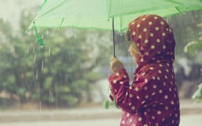 Little child walking in the rain