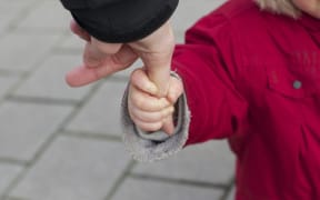 Child hand holding thumb
