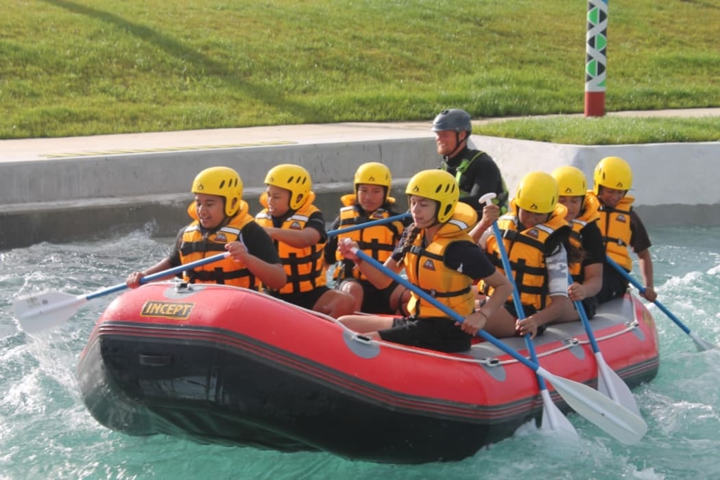 An image of students in an inflatable raft travelling down the whitewater river course.